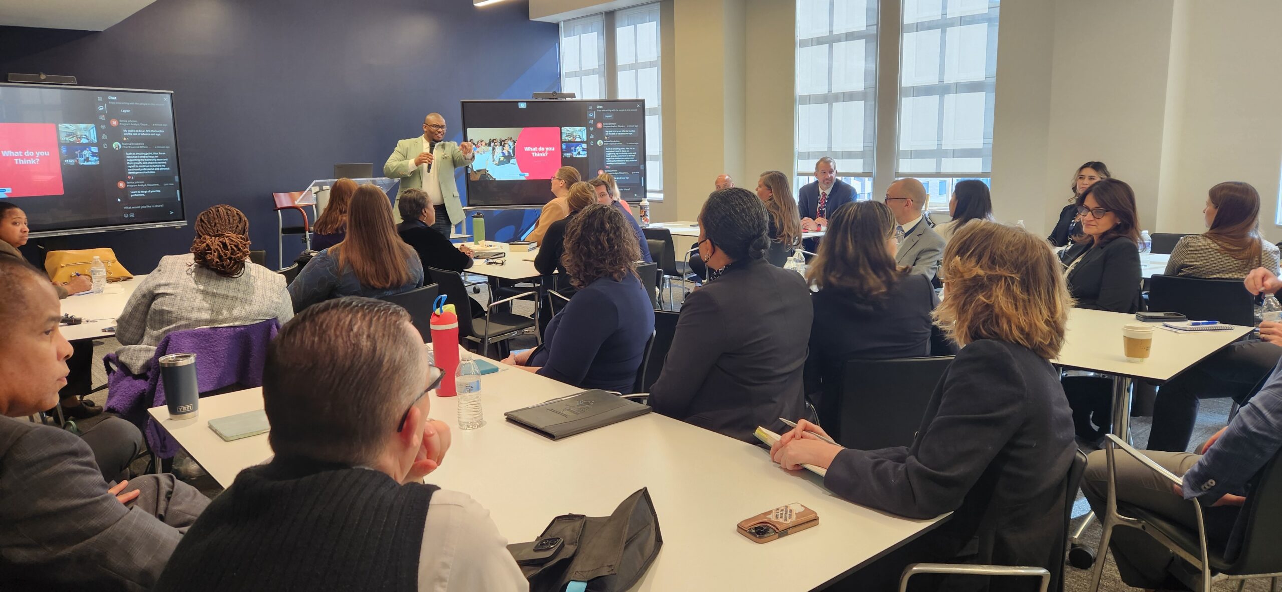 Alex Tremble presenting to a group of Senior Executive Service leaders